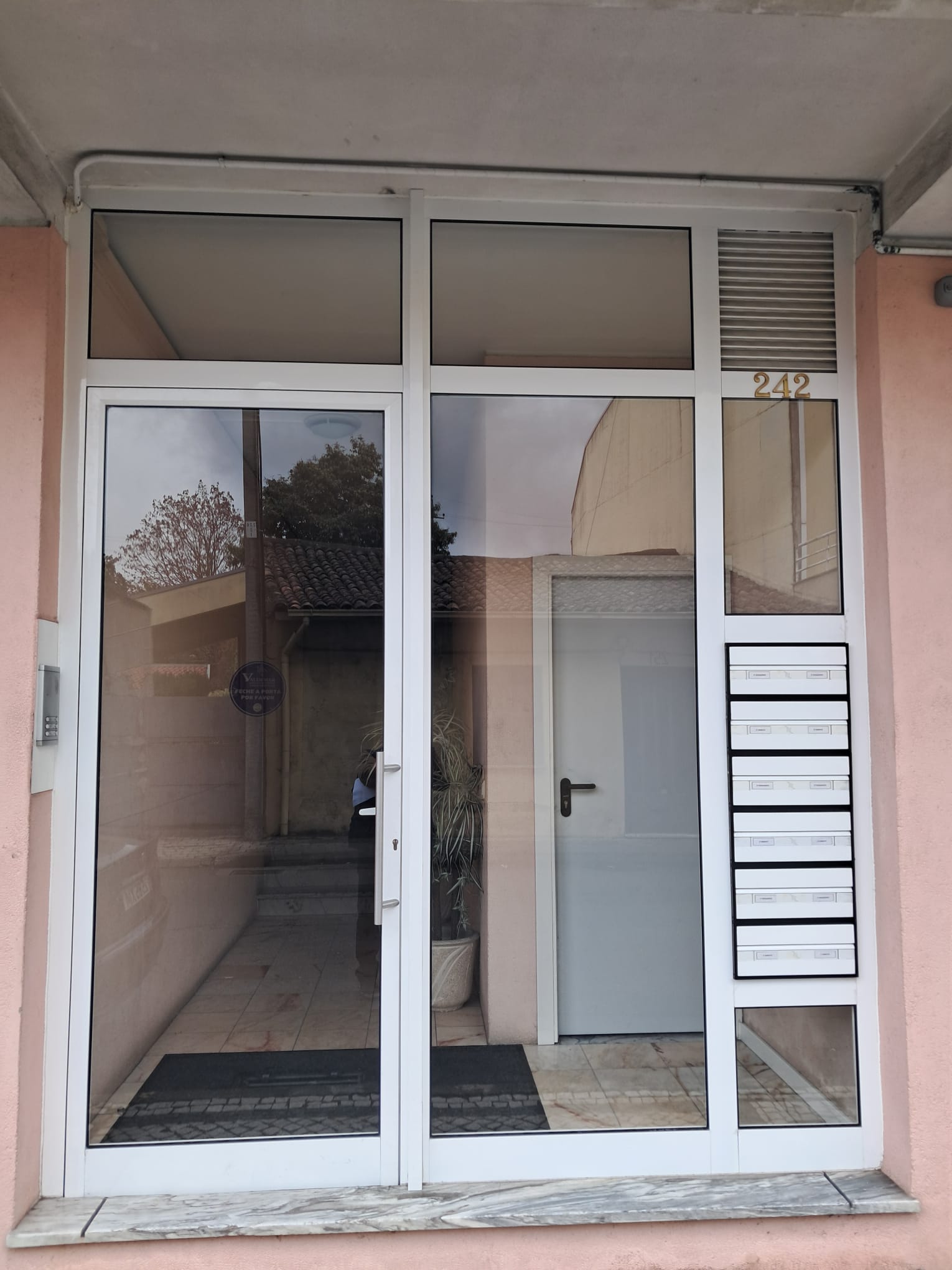 Porta de entrada em alumínio branco numa moradia — projeto residencial